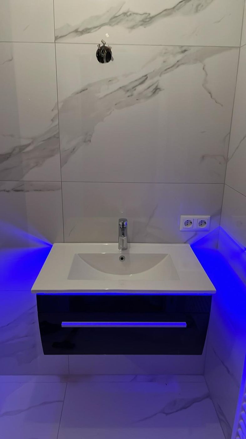 Waschtisch mit LED-Beleuchtung vor Marmorfliesen