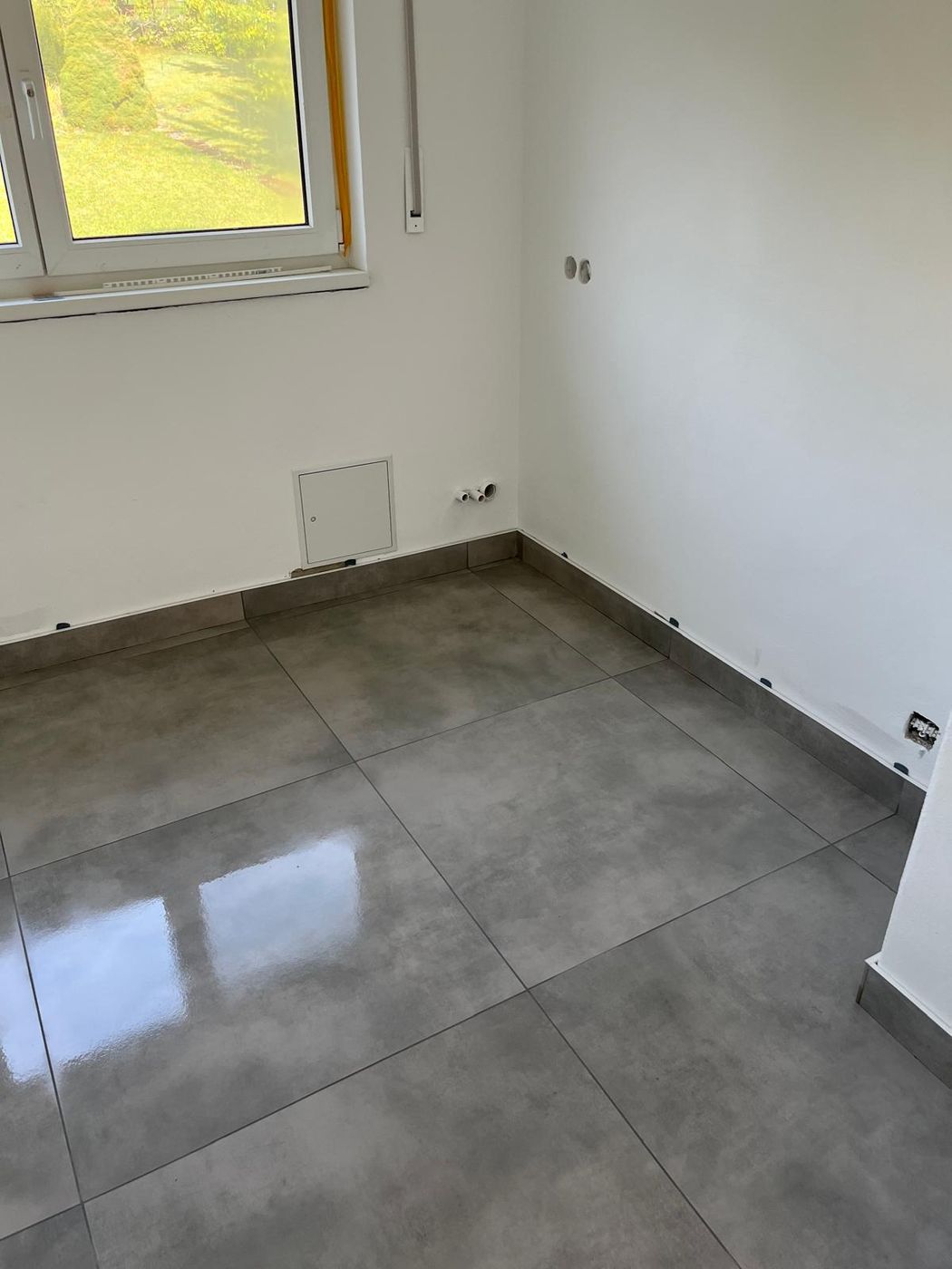 Grauer Feinsteinzeugboden in hellem Raum